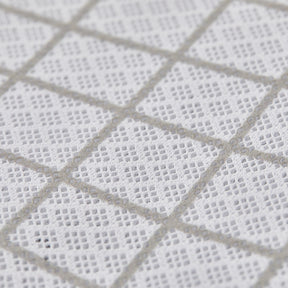 Close-up of a textured white fabric with a diamond pattern